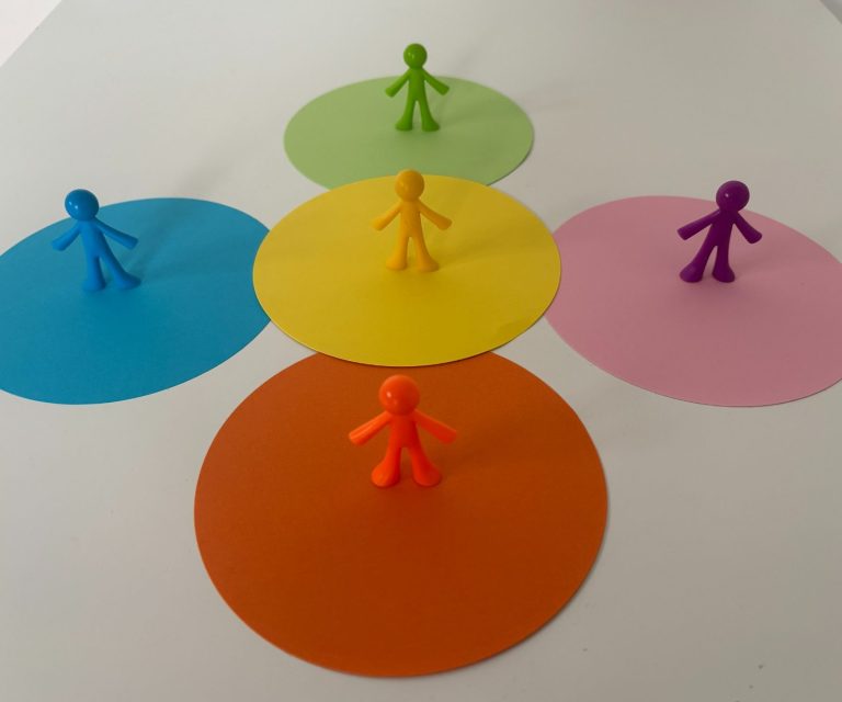 Bunte Kreise in verschiedenen Farben mit kleinen Figurenspielzeug in der Mitte.